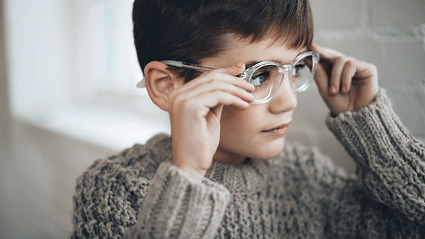 Boy with grey jumper and glasses