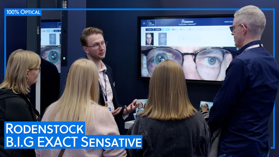 A group listen to a presentation on the Rodenstock booth at 100% Optical