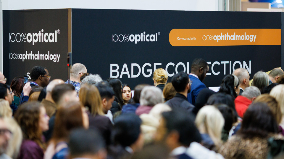A crowd gathers at the badge collection point before entering 100% Optical