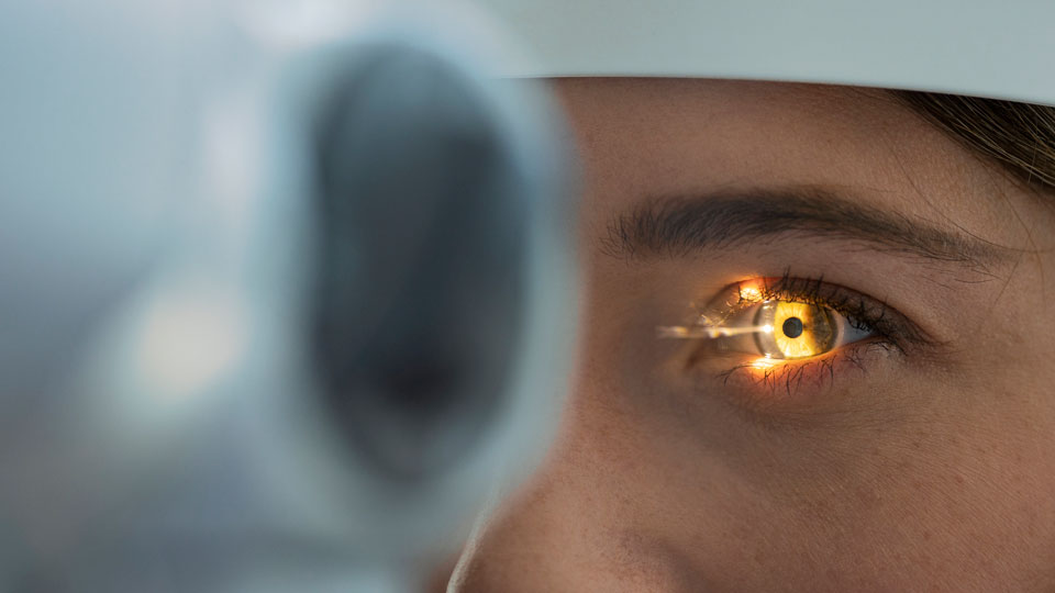 Light beam is shining through retina and lens on eyesight exam