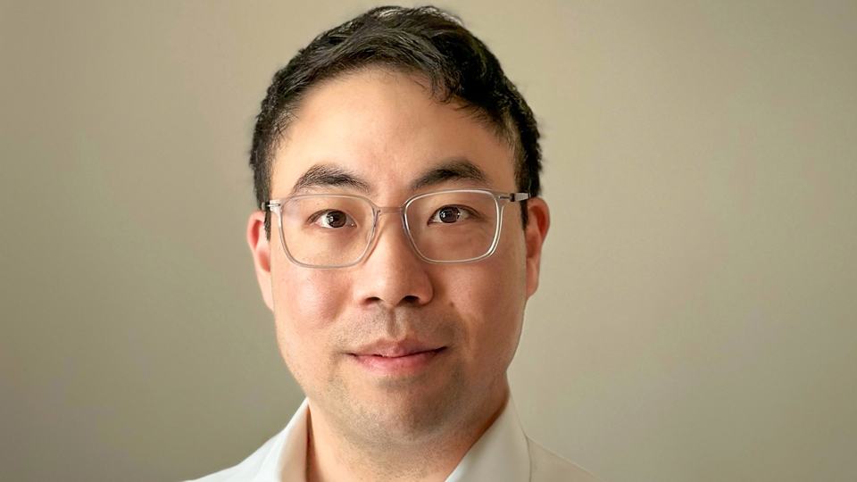 Matthew Chan wears a white shirt and clear acetate spectacles