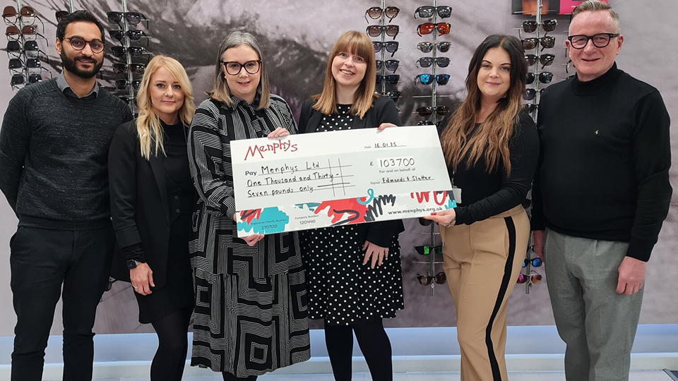 A row of people are standing in front of a frame display holding a big cheque