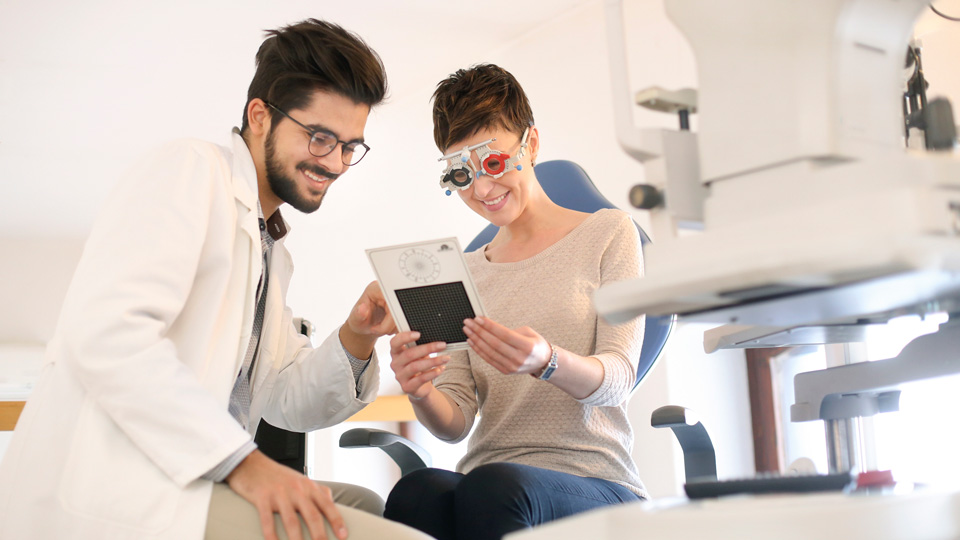 Woman having a sight test talking to a male optometrist 