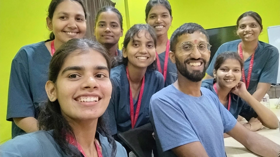 Benji Chandra is smiling with a group of people during his volunteering trip 