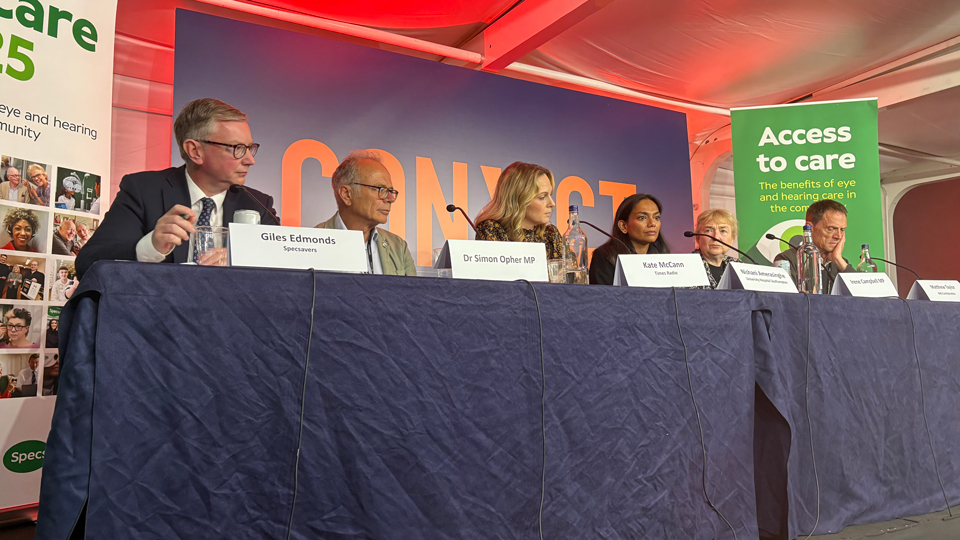 Speakers say behind a table on an elevated platform during the Specsacers panel