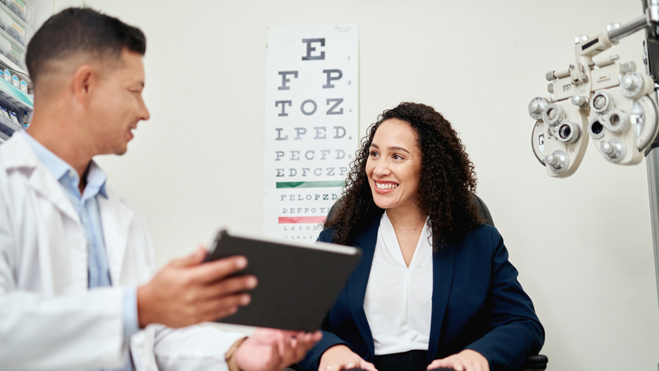 An optometrist talking to the patient in the testing room