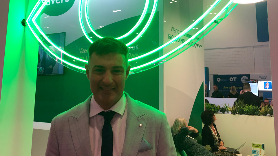 Neil is photographed at a professional event 100% Optical