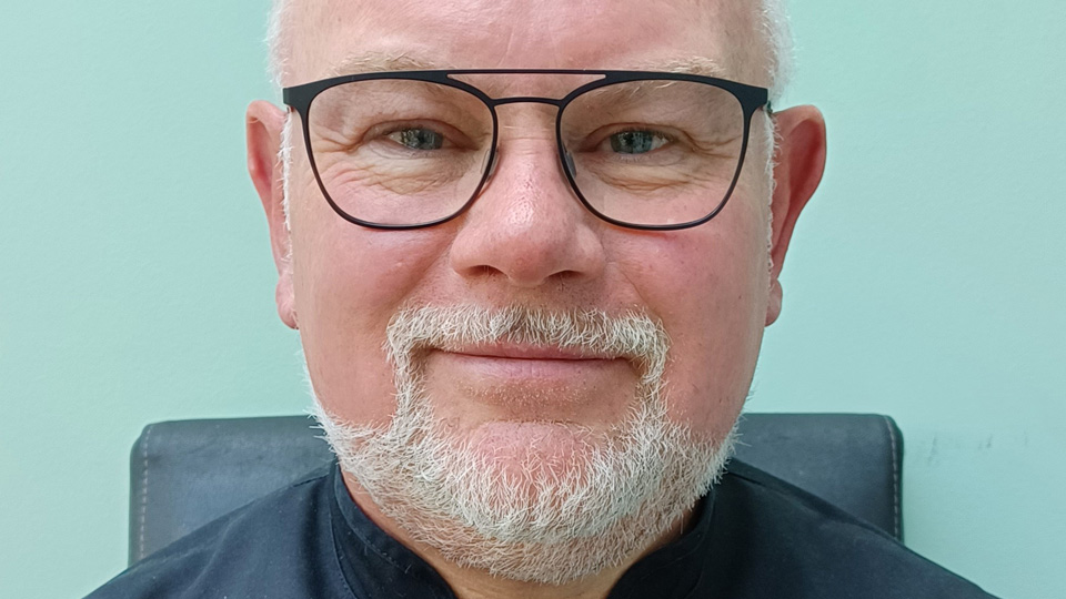 Marc Drake smiling in black glasses in a head and shoulders shot