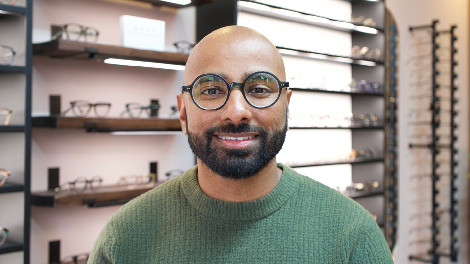 Headshot of Dipesh Patel smiling in a green rollneck jumper