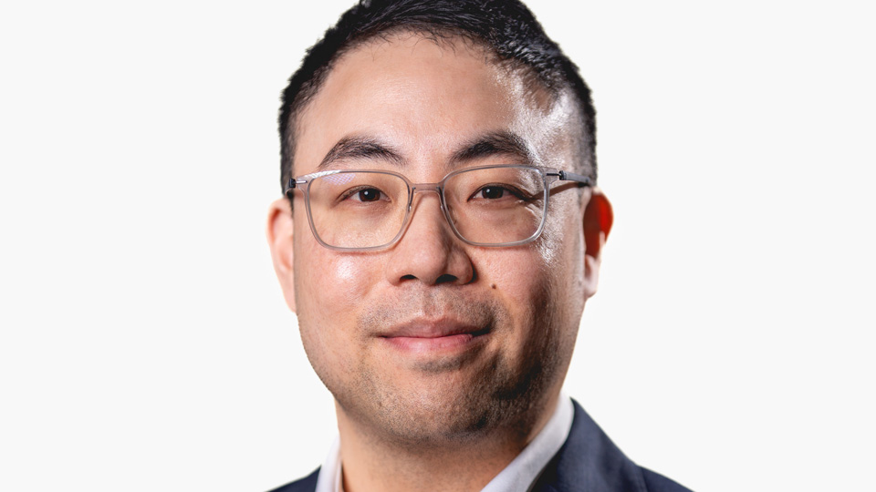 Head and shoulders shot of Matthew Chan in a suit