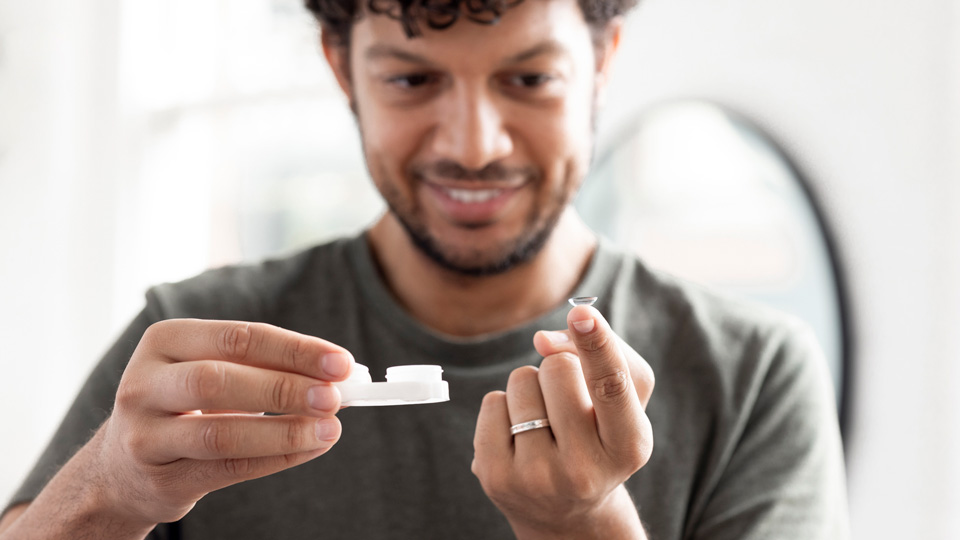 Man putting in a contact lens
