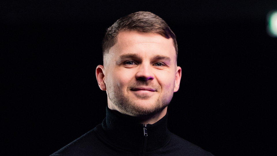 Charlie King smiling on a black background
