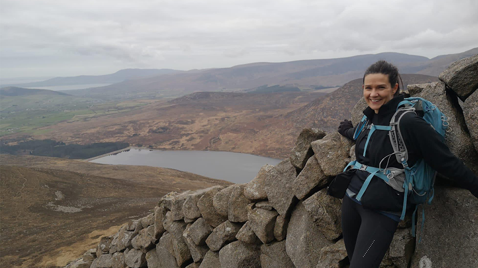 Faith Mills next to a wall on a hill
