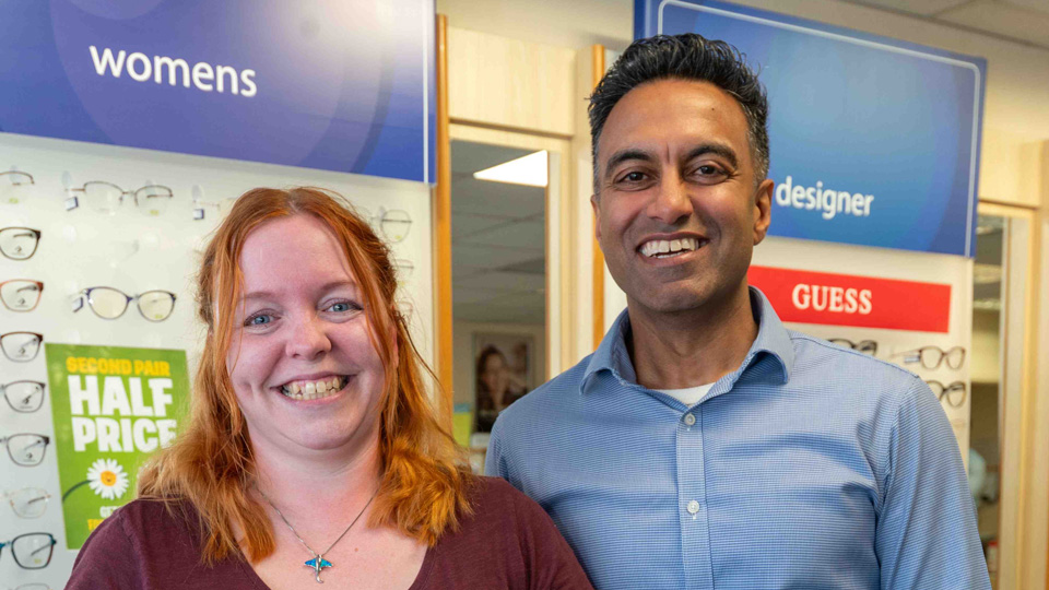 Hannah Mockler and Sameer Mistry stand together inside a Scrivens practice. Both are smiling