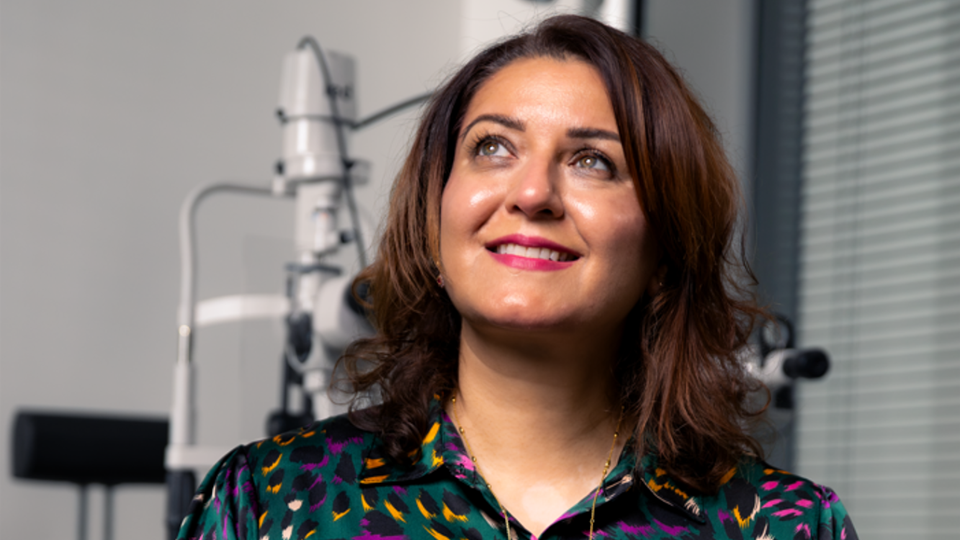 Raina Malik with arms crossed smiling away from the camera