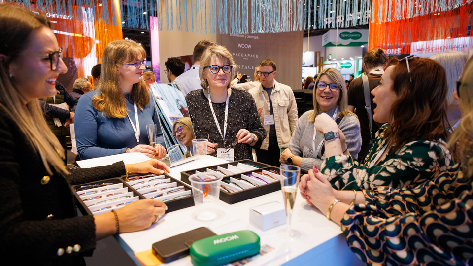 Delegates talking on an eyewear stand at 100% Optical 2025