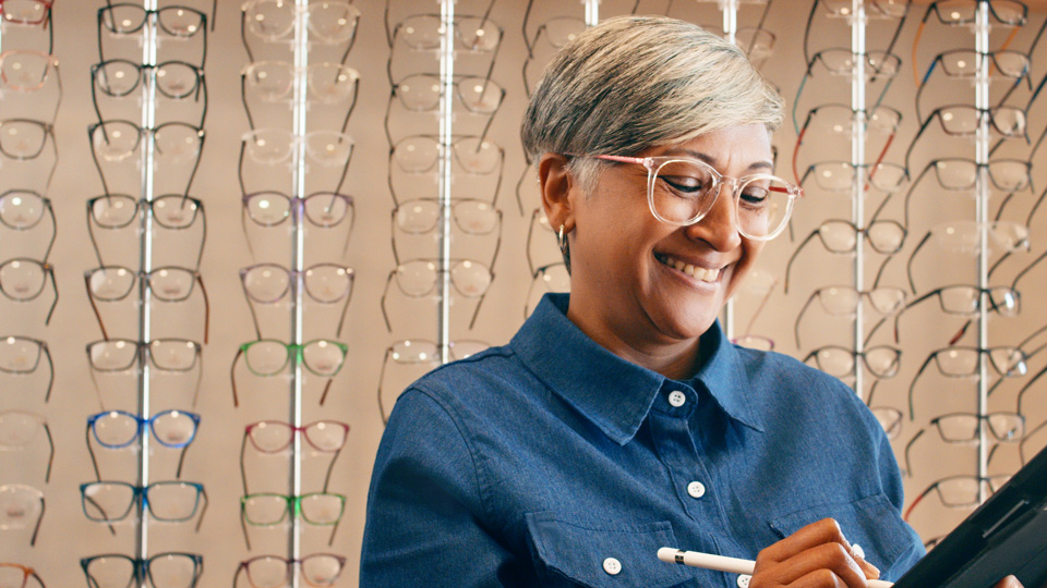 Woman wearing spectacles standing in an opticians 