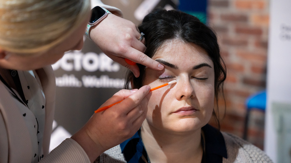 A woman with brown hair being swapped under the eye