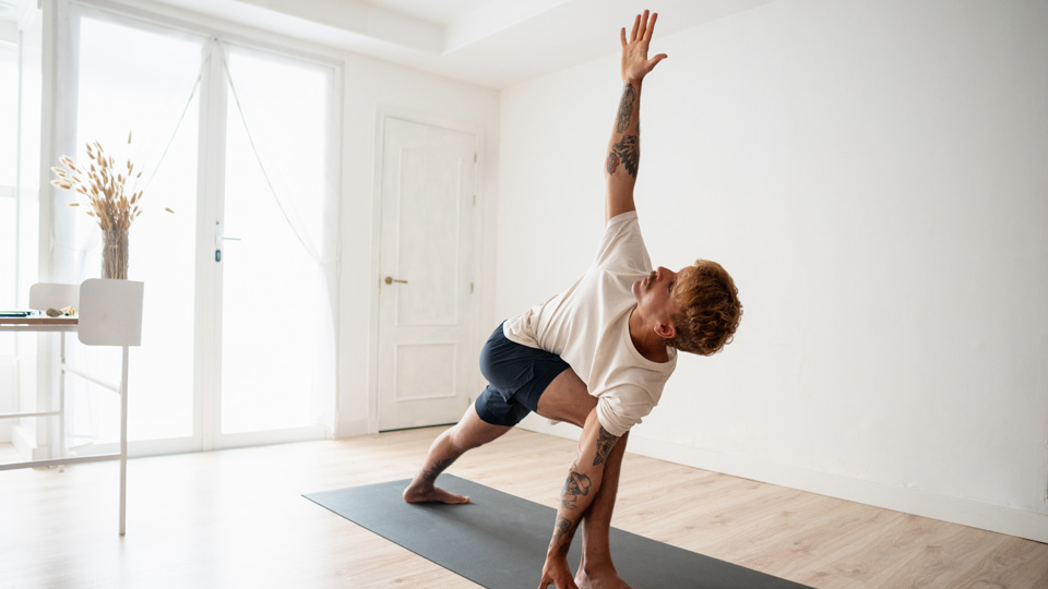 A man performs yoga in a living room