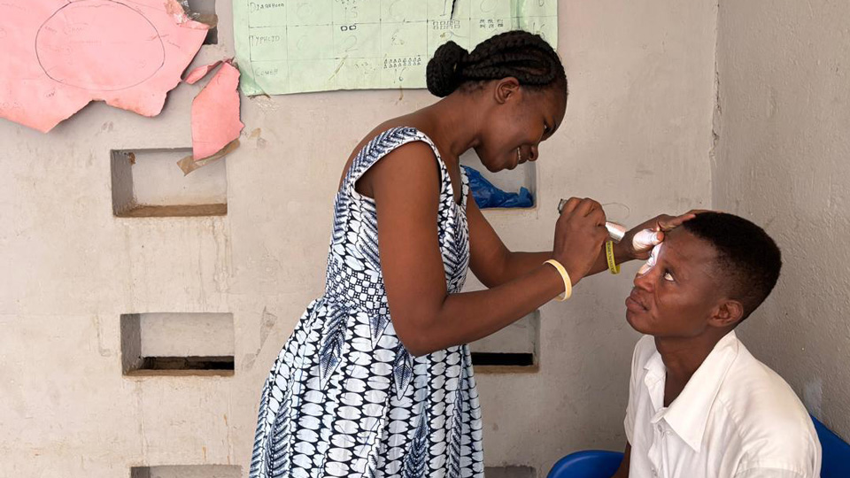 Alberta performs a basic eye check on a community member