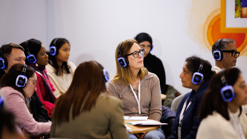 A rapt seminar audience at 100% Optical all wearing headsets