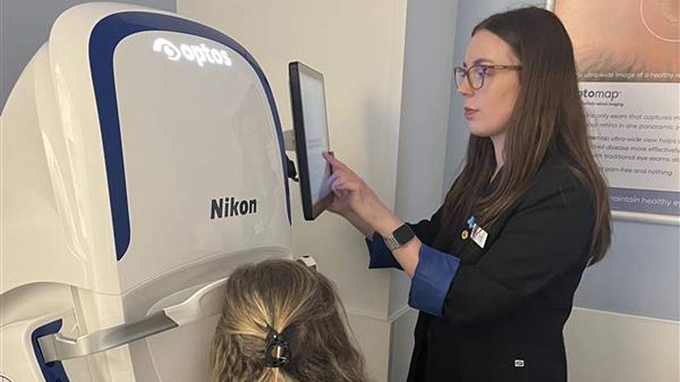 A practitioner performs an optomap scan on a patient
