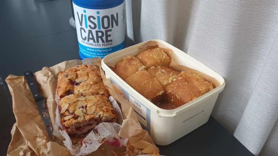 A display of cakes and cookies with a fundraising bucket for VCHP
