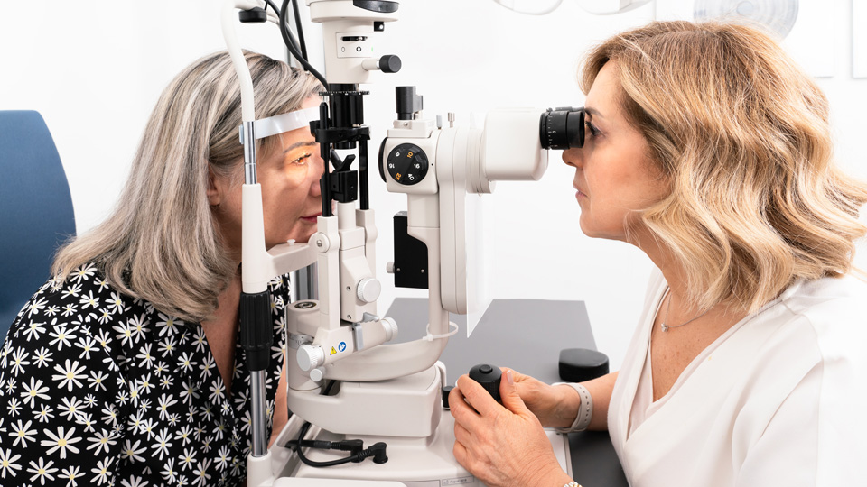 A female optometrist tests the sight of an older female patient