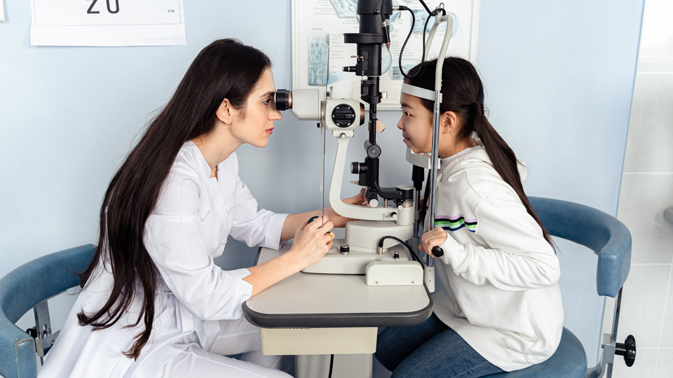 A practitioner performing an eye examination for a child
