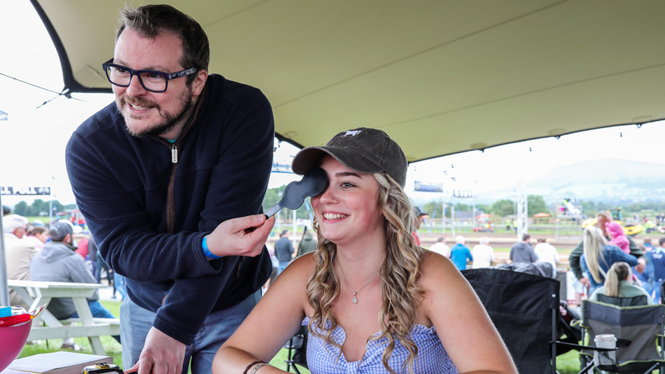Optometrist Ben Armstrong carrying out a vision check with a young lady at Revvv it Up festival