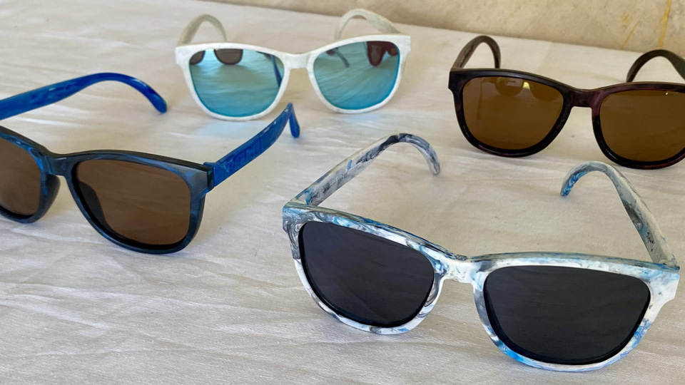 Four sunglasses made from recycled plastic arranged in a square