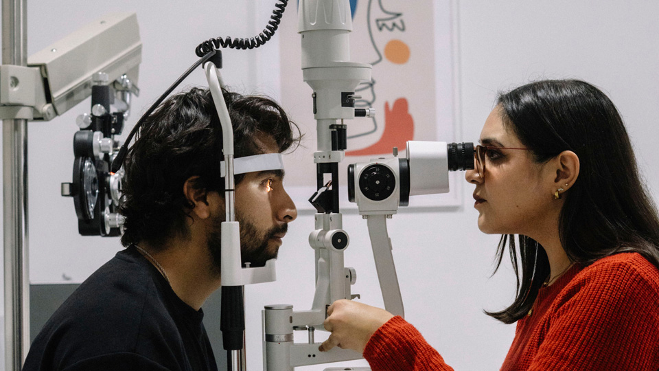 An optometrist performs a sight test for a patient
