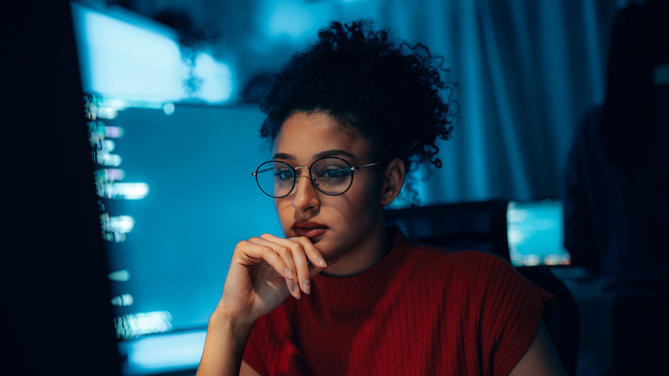 A woman looks at a computer screen