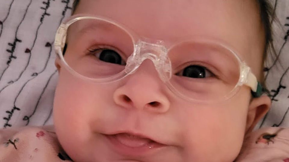 A baby is pictured wearing glasses