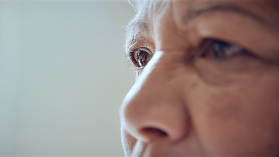 An older woman’s face is shown close up