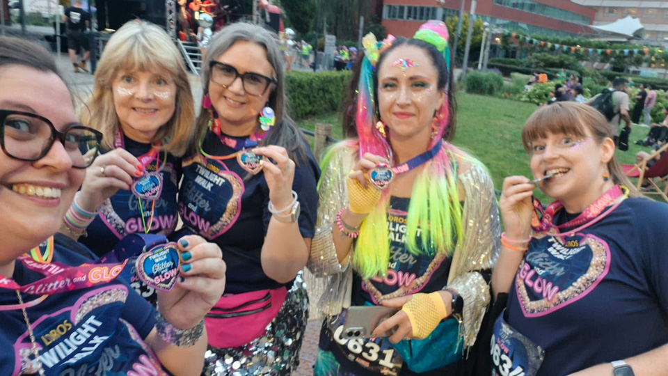 Five participants smile and hold up their finishers