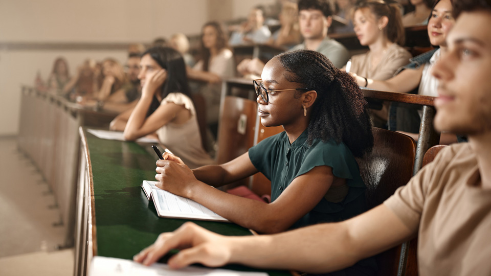 An audience faces forward in a lecture theatre