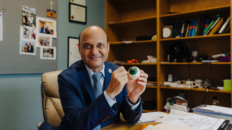 Dr Nawajes Mandal holds a model eye