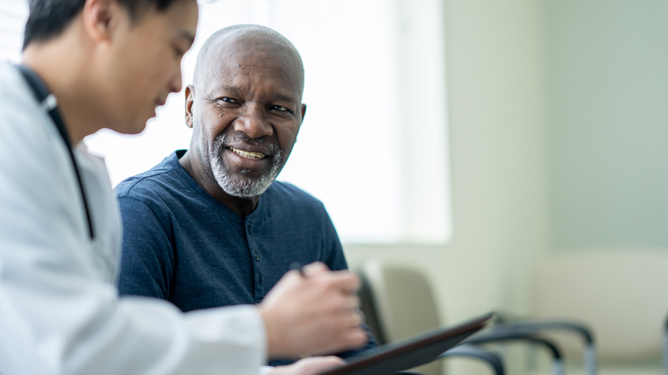 An older man has a consultation with a clinician