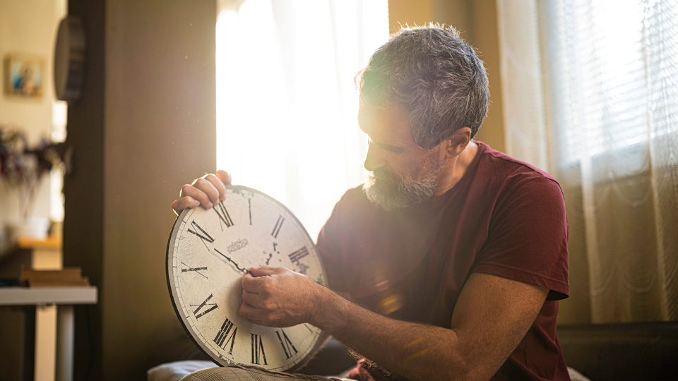 A man adjusts a clock