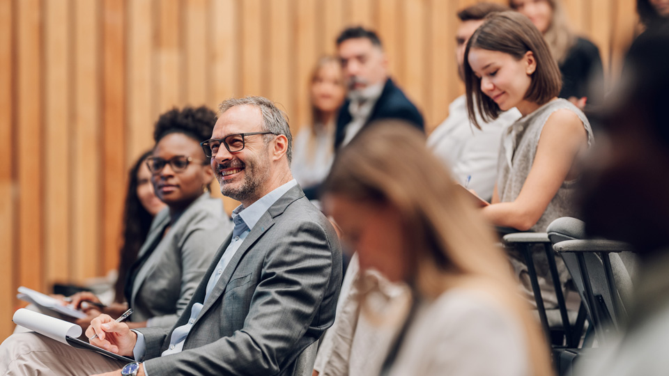 A group of professionals are seated at a conference