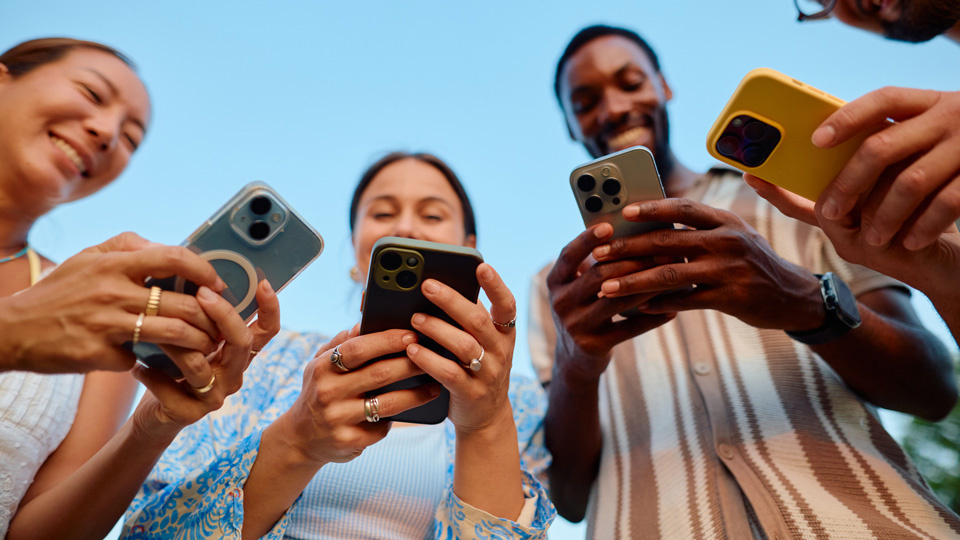 A circle of people scroll on their smartphones