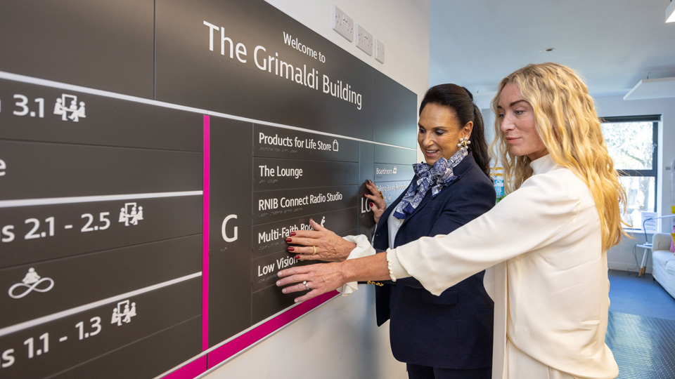 Dame Gail Ronson DBE and Victoria Smurfit inspecting the tactile signage on a tour of the RNIB’s Grimaldi building in London