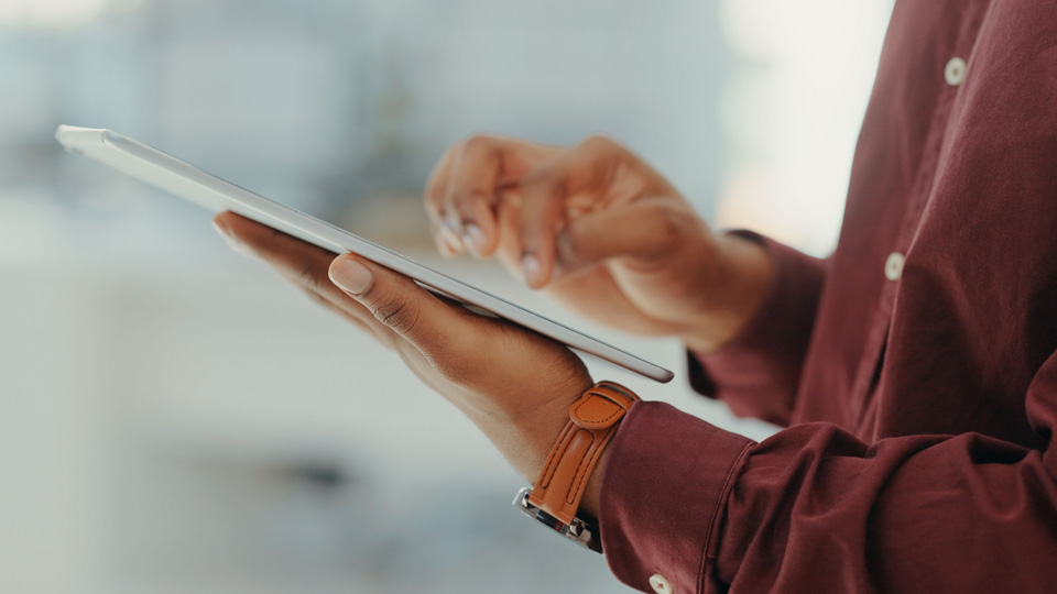 Close up of a person’s hands holding an iPad