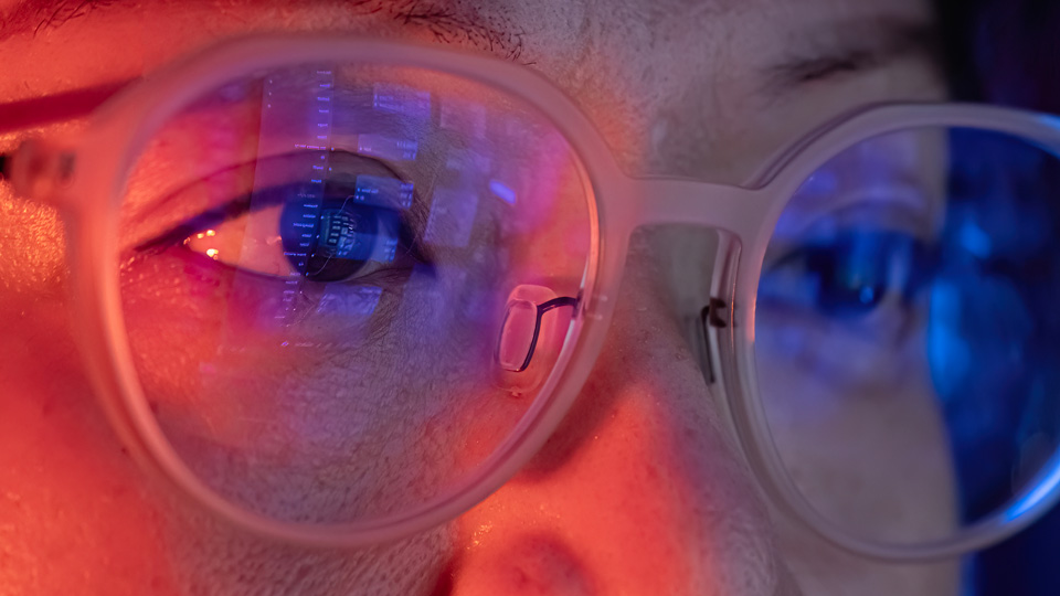 Text on a computer screen is reflected in the lenses of a person’s glasses
