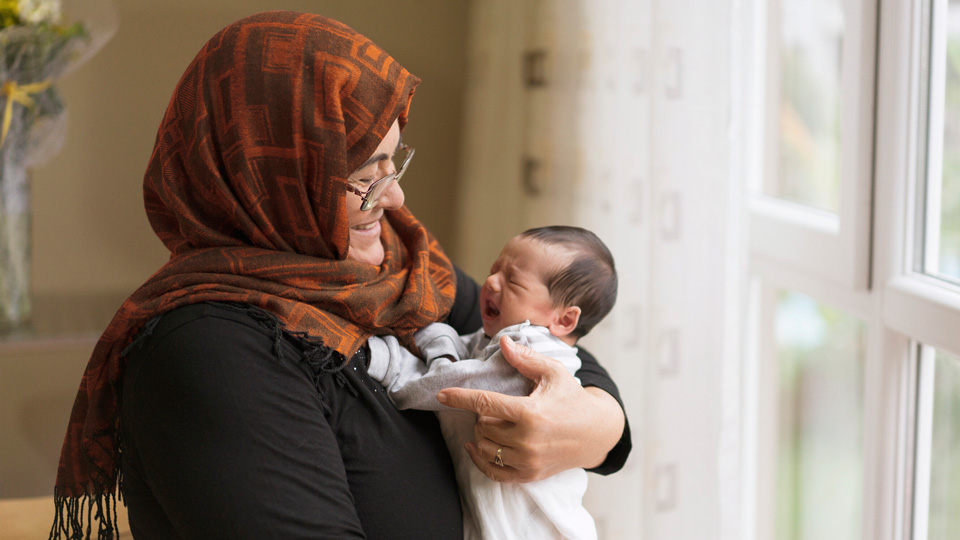 Lady smiling holding a baby