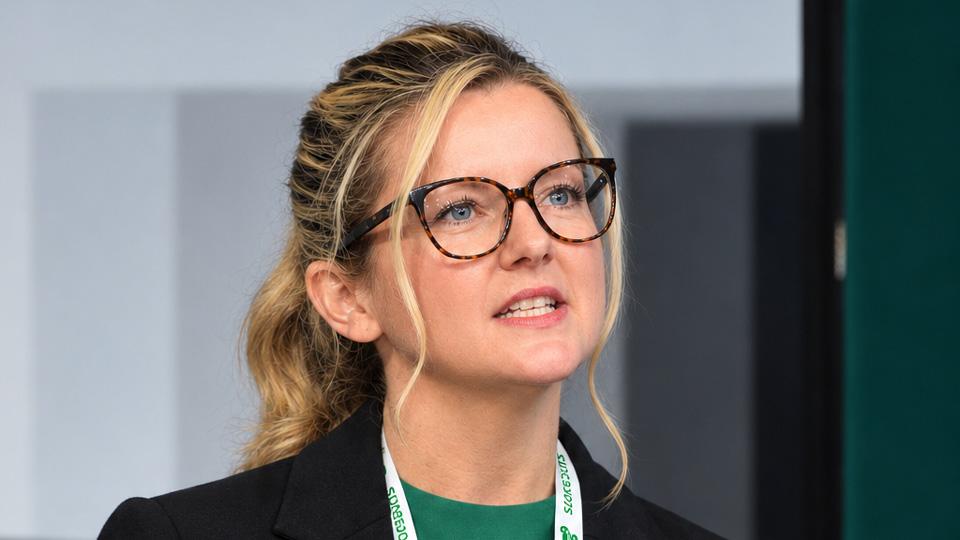 Kirsteen is mid-presentation from a lectern at a conference