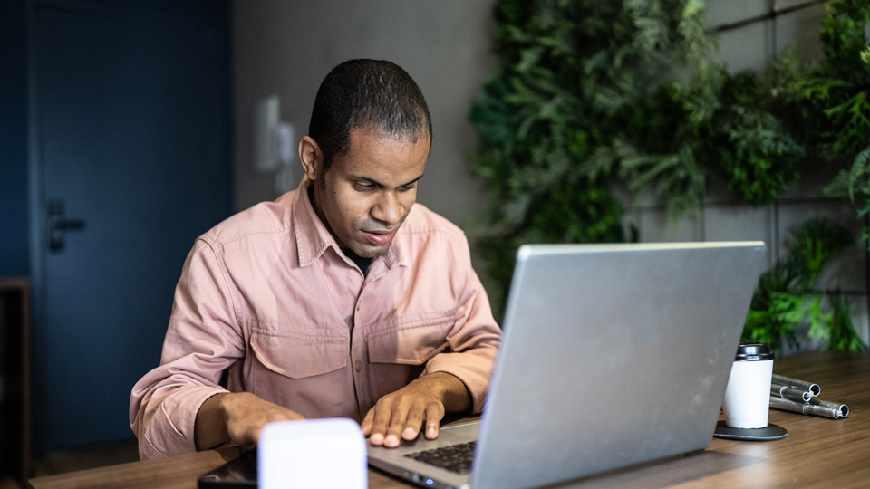 A man with sight loss uses a laptop at a desk