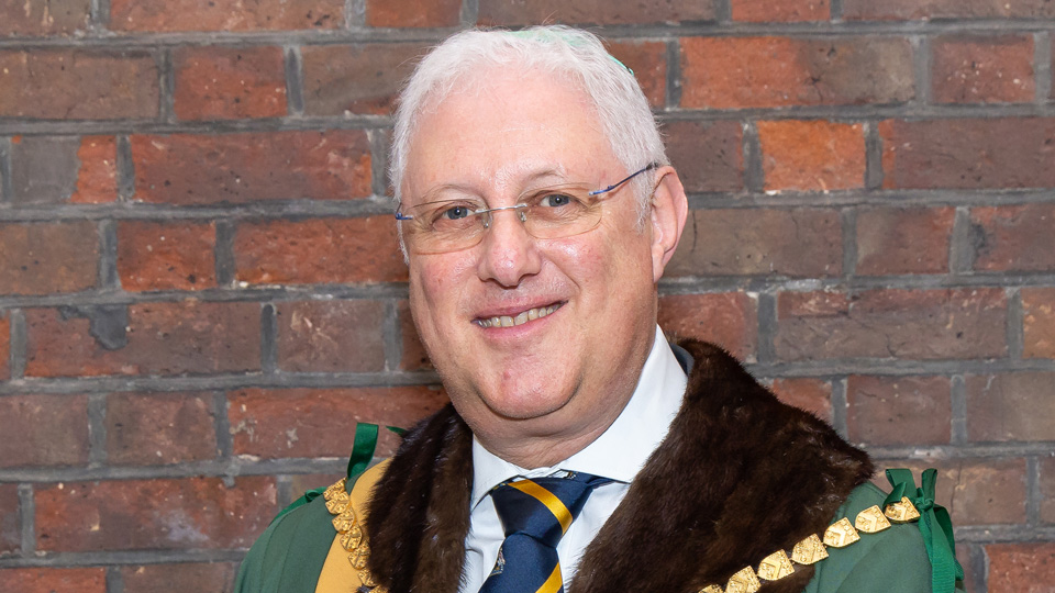 Man smiling with white hair and glasses 