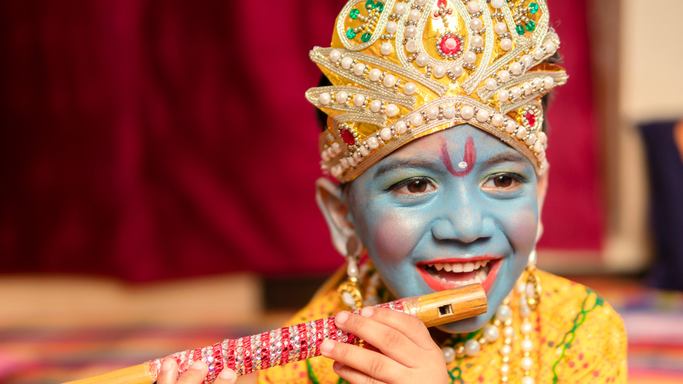 A boy is dressed as Lord Krishna for Janmashtami celebrations